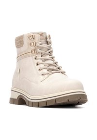 Botas de tobillo beige con un acabado de ante suave, cordones en la parte delantera, cuello acolchado y suela de goma resistente. Presenta ojales de metal y acentos decorativos.