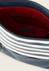 Bolso de cuero navy con franjas blancas, con un interior rojo y un bolsillo con cremallera. Forrado con una textura suave, diseño duradero.