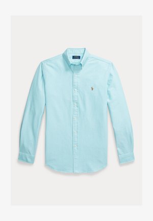 Lyseblå langermet skjorte laget av bomull, med krage med knapper, frontknapper og en liten brodert logo på brystet.