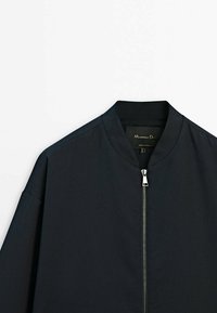 Zwarte bomberjack met een ronde kraag, ritsafsluiting aan de voorkant en een gladde, matte textuur. Eenvoudig design zonder zichtbare patronen of accenten.