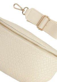 Marsupio in finta pelle color crema con texture intrecciata, zip dorata e una tracolla beige removibile con moschettone in metallo.