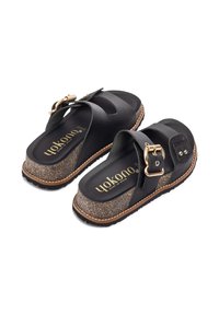Sandali neri in pelle con una fascia texturizzata, accentuata da una fibbia dorata, piedi in sughero e suola in gomma. Presentano un design con leggero plateau.