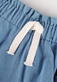 Hellblaue Denim-Shorts mit elastischem Bund und weißem geflochtenem Kordelzug. Mit gerafftem Stoff an der Taille.