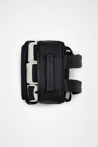 Zaino nero con finitura opaca, dotato di spallacci regolabili, una tasca frontale e scomparti imbottiti beige. Texture liscia e chiusura con zip.