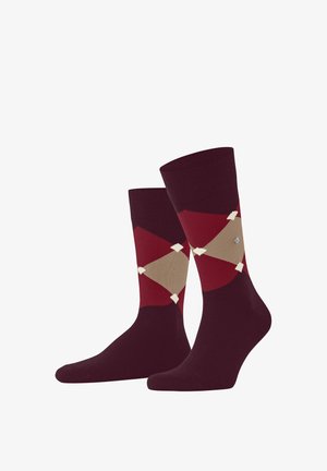 Paar Socken mit Argyle-Muster in Kastanienbraun und Rot mit beigen Rauten und kleinen weißen Akzenten auf weißem Hintergrund.