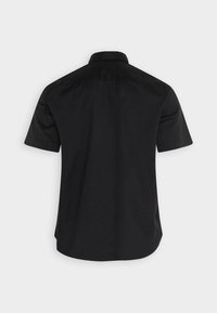 Zwarte kortmouwenshirt met een kraag, een gladde textuur en een gebogen zoom. Eenvoudig ontwerp, zonder zichtbare patronen of versieringen.