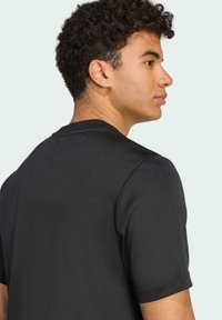 Sort kortærmet t-shirt med rund halsudskæring, der har en glat tekstur og et enkelt design. Ingen synlige mønstre eller accenter.