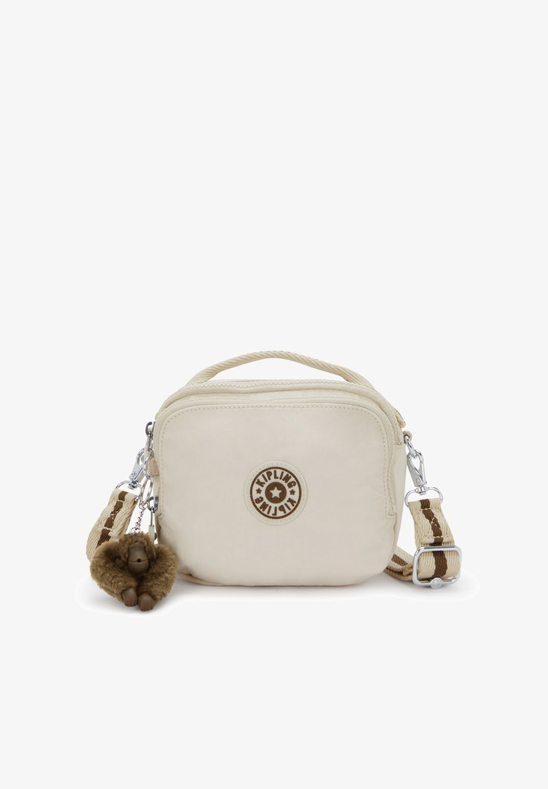 Cremfarbene Umhängetasche mit strukturierter Oberfläche, versehen mit einem runden Logo, silbernen Beschlägen und einem pelzigen Affenanhänger.