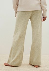 Lichtbeige wijde broek van zacht, textuurmateriaal. Voorzien van ribbels aan de onderkant. Eenvoudig ontwerp met een comfortabele pasvorm.