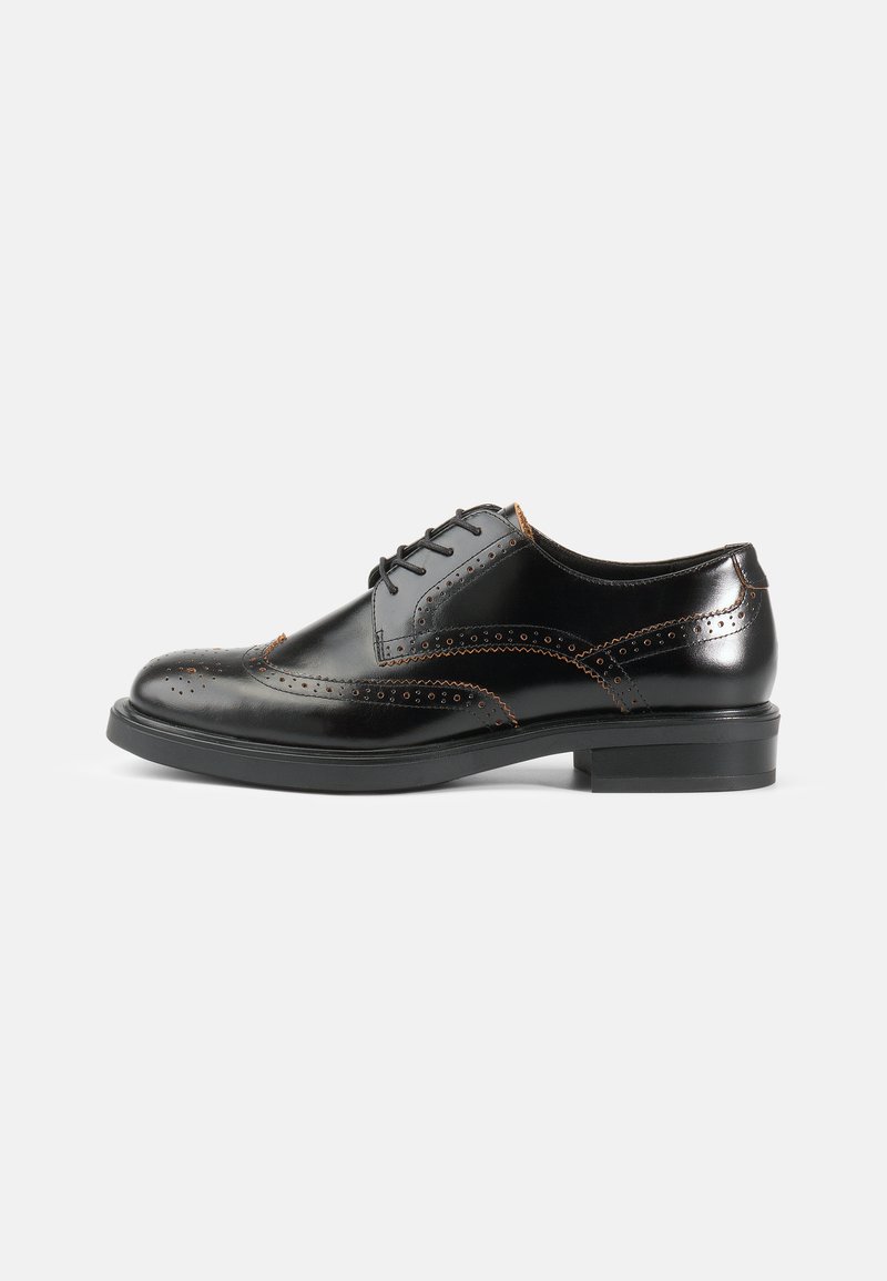 Sorte skinnsko med brogue-detaljer, slank avrundet form, svart såle og kontrasterende oransje sømmer langs sømmene.