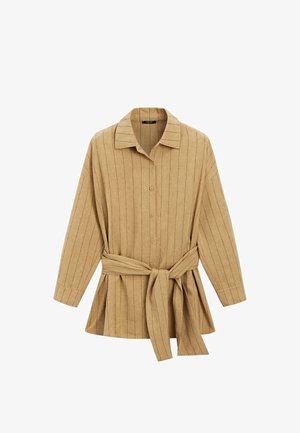 Béžová košile s dlouhým rukávem s černými vertikálními pruhy, zapínání na knoflíky vpředu, širolý límec a pásek ze stejného materiálu uvázaný v pase.