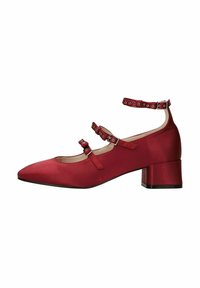 Chaussure en satin rouge à talon moyen avec bout pointu, brides de cheville et détails de boucle réglable. Texture lisse avec un design épuré.