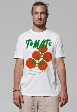 Witte t-shirt met korte mouwen, versierd met rode tomaatgraphics en groene tekst. Casual fit met een ronde halslijn en een zachte katoenstructuur.