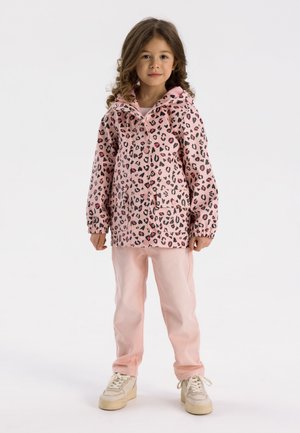 Roze luipaardprint regenjas met capuchon, lange mouwen en een voorzak; gecombineerd met lichtroze broek en crèmekleurige sneakers.