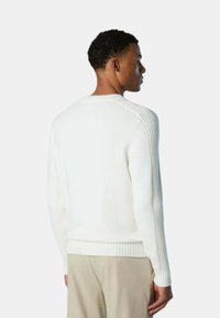 Maglione bianco a maglia con polsini e orlo a costine, caratterizzato da una texture a costine verticale sulle spalle e sulle maniche. Collo a giro classico.