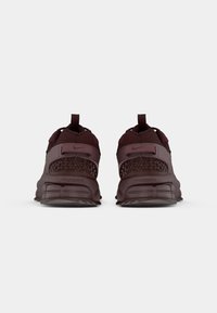 Tenisi Nike, culoare grena, superior din plasă și material sintetic, guler căptușit, talpă din cauciuc, branding proeminent și amortizare cu aer vizibil la călcâi.