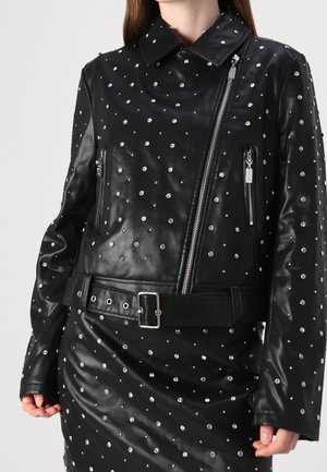 Ensemble veste en cuir noir et jupe décoré de clous ronds argentés uniformément espacés, avec une fermeture éclair asymétrique et une ceinture avec boucle.