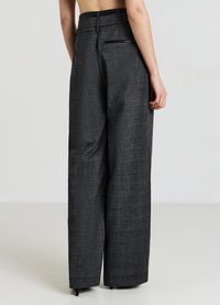 Maßgeschneiderte weite Hosen in Schwarz- und Graupattern, mit hoher Taille und einer hinteren Tasche. Hergestellt aus strukturiertem Stoff.