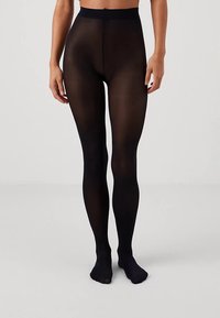 Mustad läbipaistvad sukkpüksid, siledat tekstuuri, kõrge vöökohaga ja täispikkuses, mis istuvad tihedalt vööst varvasteni.