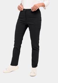 Zwarte rechte broek met een gladde afwerking, voorzien van een knoopsluiting en twee vozakken, gecombineerd met witte sneakers.