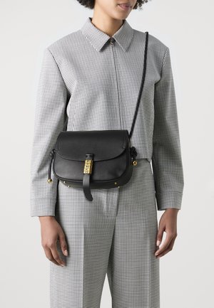 Black leather crossbody bag with a rounded shape, yellow hardware featuring “PINKO” branding, and a textured finish on the flap.