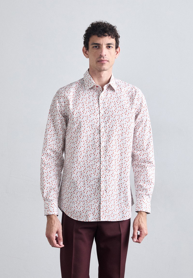 White button-up shirt with a red floral pattern, long sleeves, and a soft fabric texture, paired with maroon trousers.