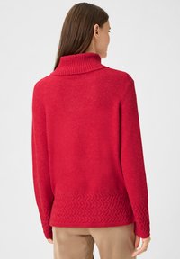 Roter Pullover mit einem gerippten Rollkragen, einem strukturierten Saum und langen Ärmeln. Weiches Material mit leicht lockerem Schnitt.