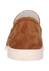 Scarpe slip-on in suede marrone con punta arrotondata e suola bianca a contrasto. Presentano una texture liscia e un design minimalista.