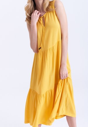 Yellow sleeveless dress with a keyhole neckline and drawstring detail, featuring a gathered tiered skirt and soft fabric texture.