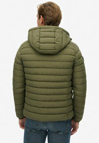 Oliwkowa, pikowana kurtka z kapturem, z poziomym wzorem pikowania, elastycznymi mankietami i dyskretnym logo na rękawie.