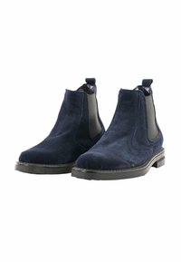 Stivali Chelsea in suede blu navy con pannelli elastici laterali, punta arrotondata e suola in gomma nera. Presentano un pratico pull tab sul tallone per indossarli facilmente.