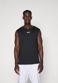 T-shirt sans manches noir en coton, avec un col rond et un logo "BOSS" blanc sur la poitrine. Texture lisse, coupe décontractée.