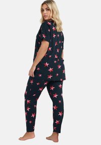 Set di pigiama navy con top a manica corta e pantaloni aderenti, entrambi decorati con motivi di stelle rosa. Tessuto morbido con una vestibilità comoda.
