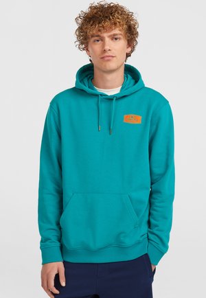 Haut à capuche teal avec une poche avant, un cordon de serrage et un patch logo orange sur la poitrine. Fabriqué en tissu doux avec une coupe régulière.