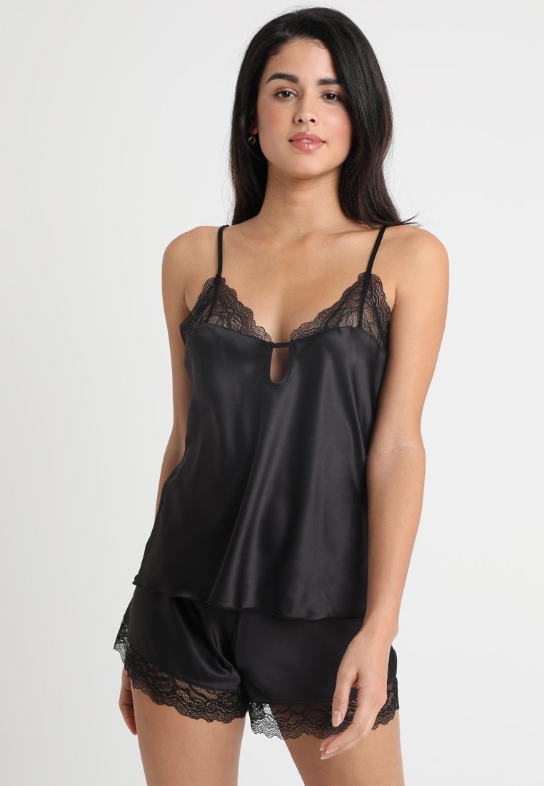 Schwarzes Satin-Cami mit Spitzenbesatz, ausgestattet mit dünnen verstellbaren Trägern und einem Schlüssellochdetail, kombiniert mit passenden Shorts mit Spitzenakzenten.