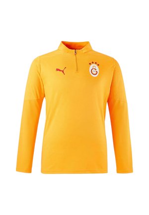 Gelbes langärmliges Sportshirt mit rotem Puma-Logo auf der rechten Brust und dem Emblem des Fußballvereins Galatasaray mit vier Sternen auf der linken Brust.