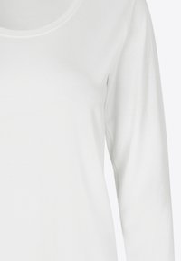 Camicia bianca a maniche lunghe con scollatura rotonda, caratterizzata da una texture liscia e morbida, senza motivi o decorazioni visibili.