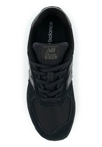 Baskets New Balance 574 noires avec une tige en daim et en mesh, fermeture à lacets, col rembourré et accents de logo gris sur les côtés.