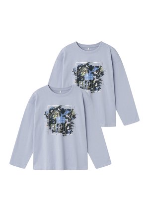 Zwei langärmlige hellblaue T-Shirts mit einem Frontgrafik, die abstrakte dunkle Farben und den Text "Glaube an dich selbst" in einem rechteckigen Design zeigt.