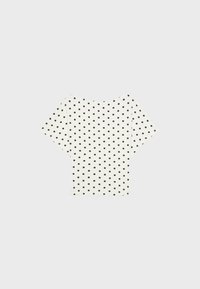 White short-sleeve top with black polka dots, boat neckline, and slightly loose fit, displayed on a light gray background.
