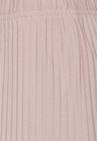 Tissu plissé rose clair avec une surface finement texturée et une ceinture élastique en haut.