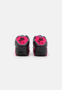 Svarte og rosa Nike Air-sneakers med teksturert overdel, polstret krage og fremtredende logo-detaljering på hælen.