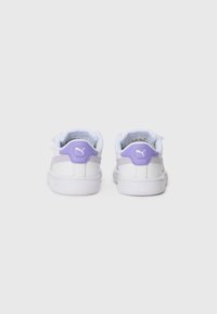 Baskets de sport blanches avec des accents violets et des détails réfléchissants. Présentent un dessus en tissu texturé et un col rembourré pour le soutien.