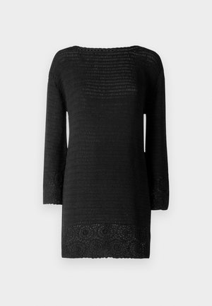 Svart strikket tunika med trekvartslange ermer, med et teksturert mønster og intrikat blondertrim ved kanten og de brede ermer.