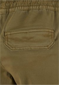 Olivgrüne Hose mit elastischem Bund und glatter Oberflächenstruktur, ausgestattet mit einer genähten, rechteckigen Gesäßtasche und Nähten.