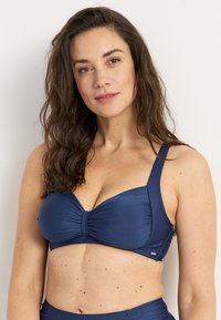 Marineblauwe bikini bovenkant, gemaakt van gladde stof, met een gedraaide voorkant, brede banden en een ondersteunende structuur.