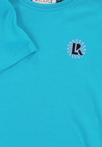 Turquoise katoenen t-shirt met een ronde hals, korte mouwen en een logo met zwarte en lavendelkleurige letters in een cirkelontwerp.