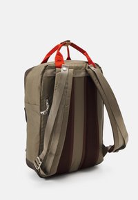 Khaki backpack with orange accents, two adjustable straps, textured mesh paneling, side pocket, and reinforced top handles.