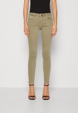 Jeans ajustados en un suave color verde olivo, fabricados con una mezcla de algodón de tacto suave. Cuentan con bolsillos frontales y un cierre clásico de botón.