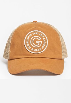 Brązowa i beżowa siateczkowa czapka z daszkiem z okrągłą białą naszywką z napisem „G GUESS Established 1981 Los Angeles” na przednim panelu.